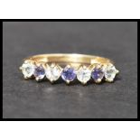 A hallmarked 9ct gold ring set with 7 white and purple alternating stones. Hallmarked Birmingham.