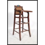 An early 20th century Chinese elm wood childs high chair having a flip over tray and foot rest.