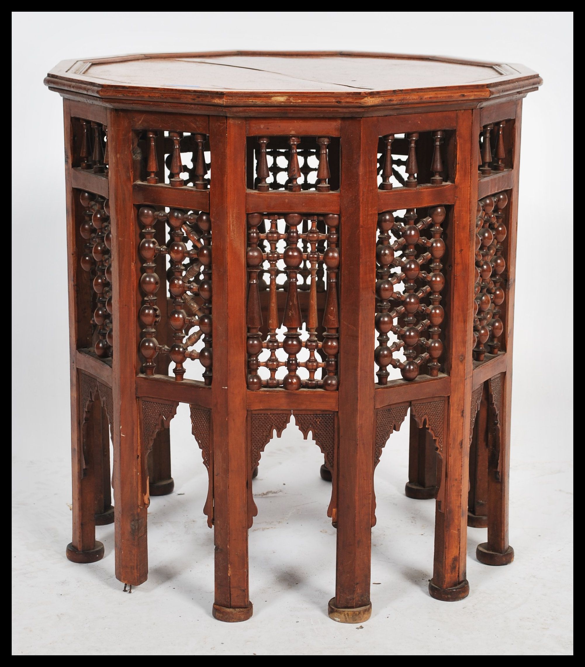 A Moroccan wooden occasional wine table having twelve sides. The dodecagonal top supported by 12