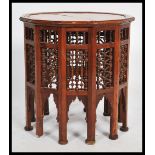 A Moroccan wooden occasional wine table having twelve sides. The dodecagonal top supported by 12
