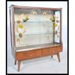 A vintage retro mid 20th century china display cabinet having glass sliding doors decorated with