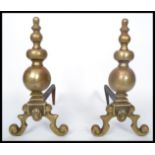 A 19th century Victorian pair of cast brass and iron fire dogs - andirons. Raised on scrolled with