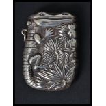 A silver vesta case having an embossed image of a crocodile. Weighs 29.7 grams.