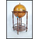 An antique style cocktail drinks cabinet in the form of a globe with hinged top section to fitted