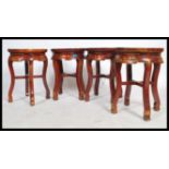 A set of four 20th century Chinese oriental stools having round tops and carved scrolls with x-frame
