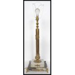 A 20th century brass table lamp having a gilt ormolu column raised on a stepped square marble