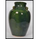 An early 20th century tall vase / water carrier in a vibrant green glaze, four string holes to the