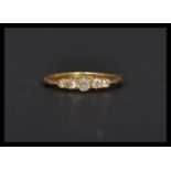 An 18ct gold ring set with 5 graduating old cut diamonds. Marked 18ct, mark worn, tests 18ct gold.