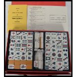 A vintage 1960's Oriental Mahjong set having wooden and resin playing pieces held within a vinyl box