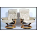 A pair of cream leather Ekornes Stressless reclining armchairs being upholstered in cream leather