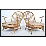 Ercol - A pair golden dawn Windsor armchairs in beech and elm, having the propeller arm rest and