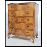 A mid century Queen Anne revival bow front mahogany bachelors chest of drawers being raised on