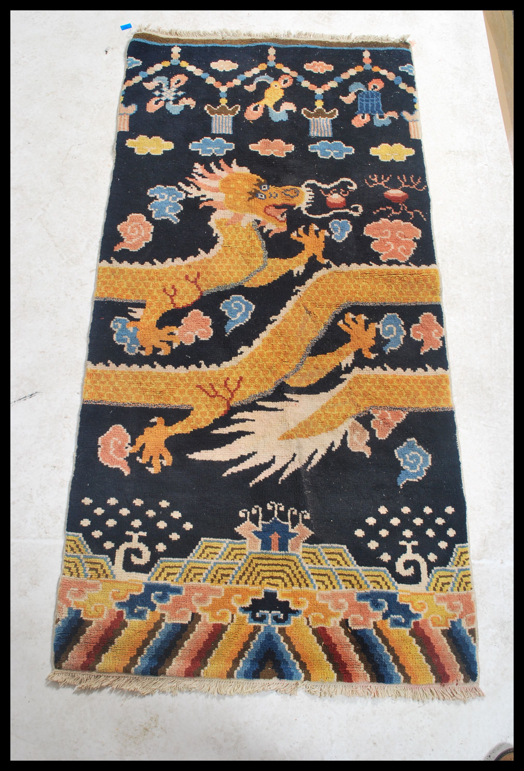 An early 20th century Tibetan dragon rug. The blue ground with large continuous dragon with