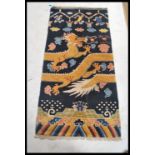 An early 20th century Tibetan dragon rug. The blue ground with large continuous dragon with