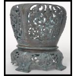 A 20th century cast bronze planter raised on splayed legs with floral sprays and medallions. The