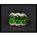 A 14ct gold ring having three tourmaline central panels surrounded by diamonds. Weighs 3.2 grams
