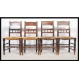 A set of four 19th century elm dining / kitchen chairs having gallery rail backs, later rush and