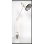A vintage 20th century Herbert Terry anglepoise desk lamp being raised on circular base with a