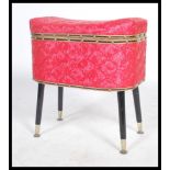 A vintage 20th century retro pink fabric work sewing box raised on four ebonised tapering legs