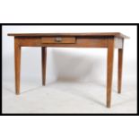 An early 20th century oak desk / farmhouse kitchen table, raised on square tapered legs, single