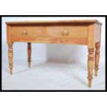 A late 19th century Victorian scrubbed pine desk, two drawers to the front raised on turned legs