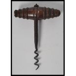 A 19th century corkscrew bottle opener having a turned wood handle. Measures 13 cm high.