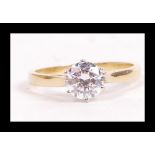 An 18ct gold and CZ solitaire ring set with a round cut CZ with pierced raised shoulders. Hallmarked