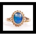 A hallmarked 9ct gold and opal style ring with a single opal doublet in a bezel setting.