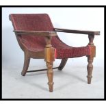 A 20th Century Plantation chair / armchair with 2 slide out arms being raise on turned legs with