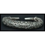 A Chinese silver bangle bracelet having an engraved foliage design. Weighs 47 grams.