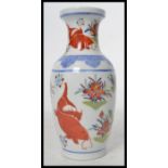 A 20th century Chinese vase decorated with scenes of carp and weeds with ochre red character marks