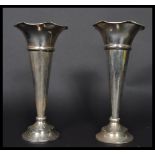 A pair of early 20th century silver hallmarked vases by Daniel George Collins raised on circular