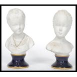 A pair of Unter Weiss Bach 1882 ceramic bust figurines of children - girl and boy raised on cobalt