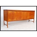 A mid century Nathan Furniture teak wood ' circles ' sideboard being  fitted with central two door