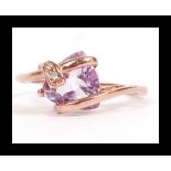 A 9ct rose gold ring set with a large purple stone with diamond accents in a contemporary setting.