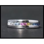 A hallmarked 9ct white gold and sapphire half eternity ring having channel set round cut multicolour