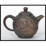 A 19th century Chinese bronze Yi Xing teapot of globular form. The body having Fu Dog decoration