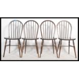 A collection of four vintage 20th century  beech and elm hoop back dining chairs in the manner of