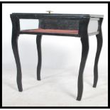 An early 20th century ebonised Bijouterie display table. Raised on sabre style supports having a