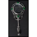 A silver magnifying glass having emerald cabochons with acanthus leaf handle. Weighs 18 grams.