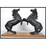 A pair of 19th century ebonised spelter marley horses rearing at each other being set over a