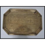 A 19th century Indian / Islamic brass tray of elongated hexagonal form profusely engraved with