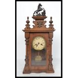 An early 20th century oak cased mantel clock having turned columns and carved applied decoration.