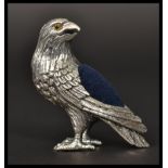 A sterling silver pin cushion in the form of an eagle with with glass eyes. In the manner of Adie