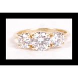 A 14ct gold and CZ trilogy ring set with 3 bright round cut CZ with bezel set CZ in heart accents to