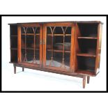 A mid 20th century mahogany glazed bookcase, a pair of central astral glazed doors flanked by open