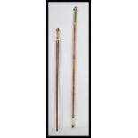 Two vintage 20th century walking stick canes having tapering shaft with ornate decorative gilt brass