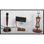 A group of three mid 20th century teak table desk lamps to include a library example and two