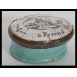 A 19th century Bilston enamel pill box pot having a pictorial lid of a house with notation reading