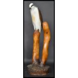 A 20th century hand carved and hand painted wooden sculpture of an Osprey / Sea Eagle sat on a